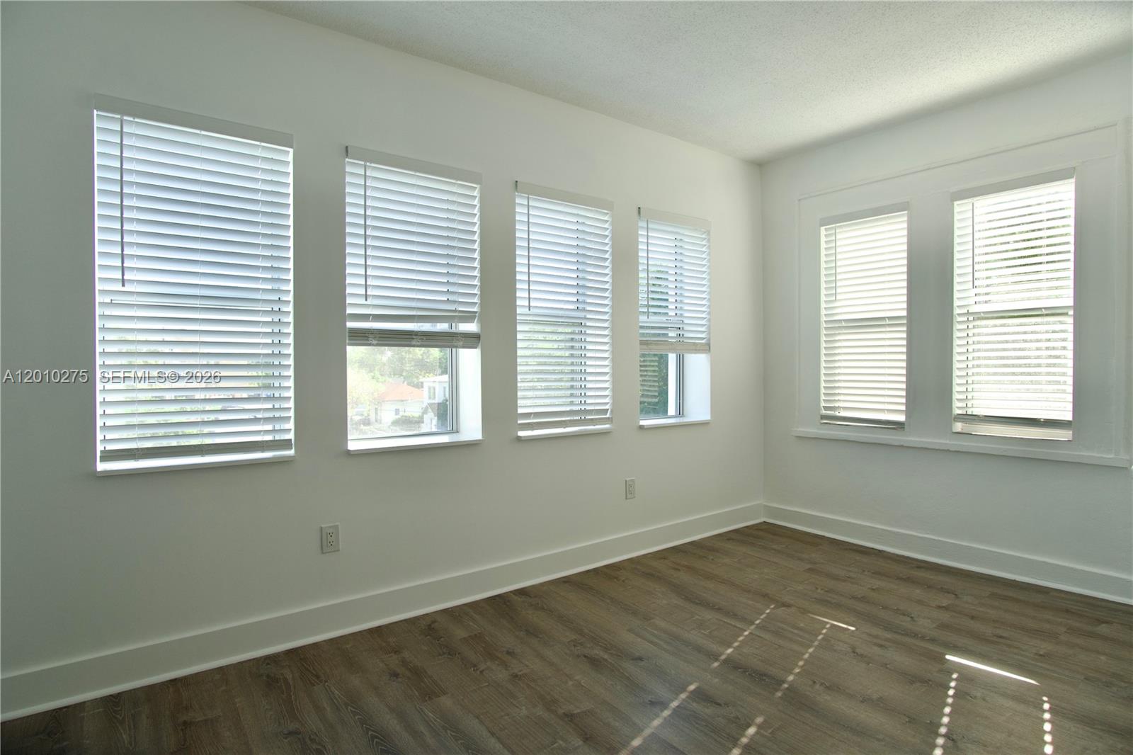 501 Southwest 6th Court, Unit 319 Miami, FL 33130 - Photo 3 of 15 a view of an empty room with wooden floor and a window