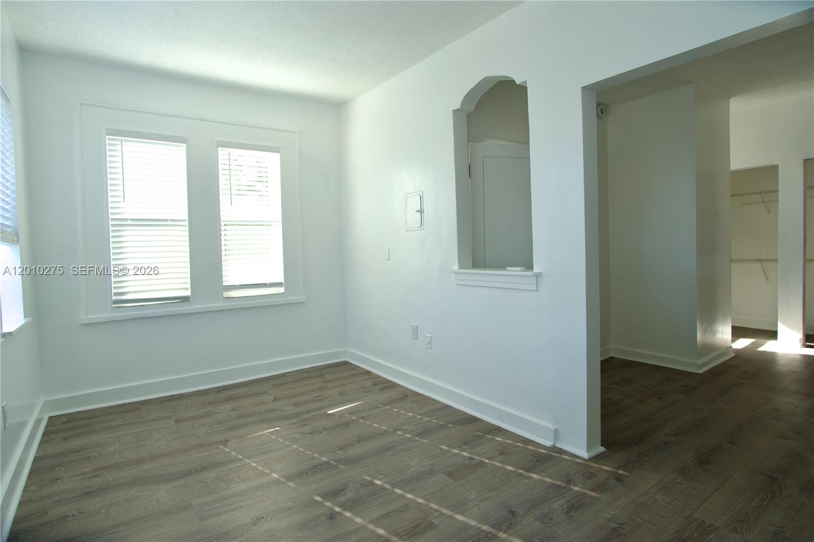 501 Southwest 6th Court, Unit 319 Miami, FL 33130 - Photo 5 of 15 an empty room with wooden floor and windows