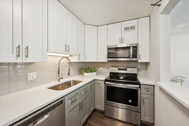 a kitchen with white cabinets and stainless steel appliances