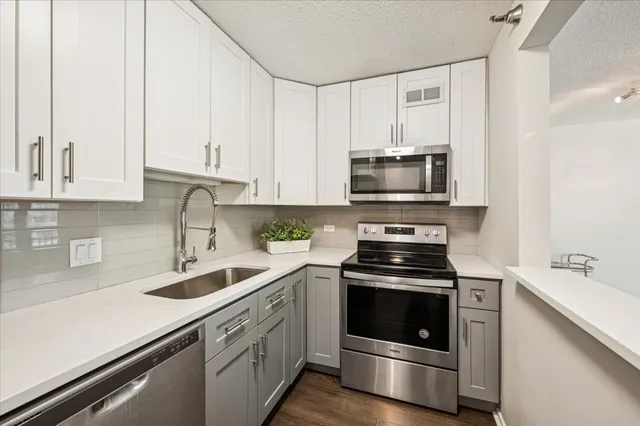 a kitchen with white cabinets and stainless steel appliances