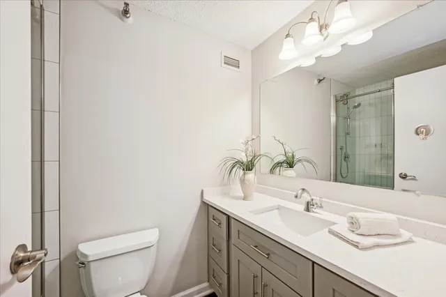 a bathroom with a granite countertop sink a toilet and a mirror
