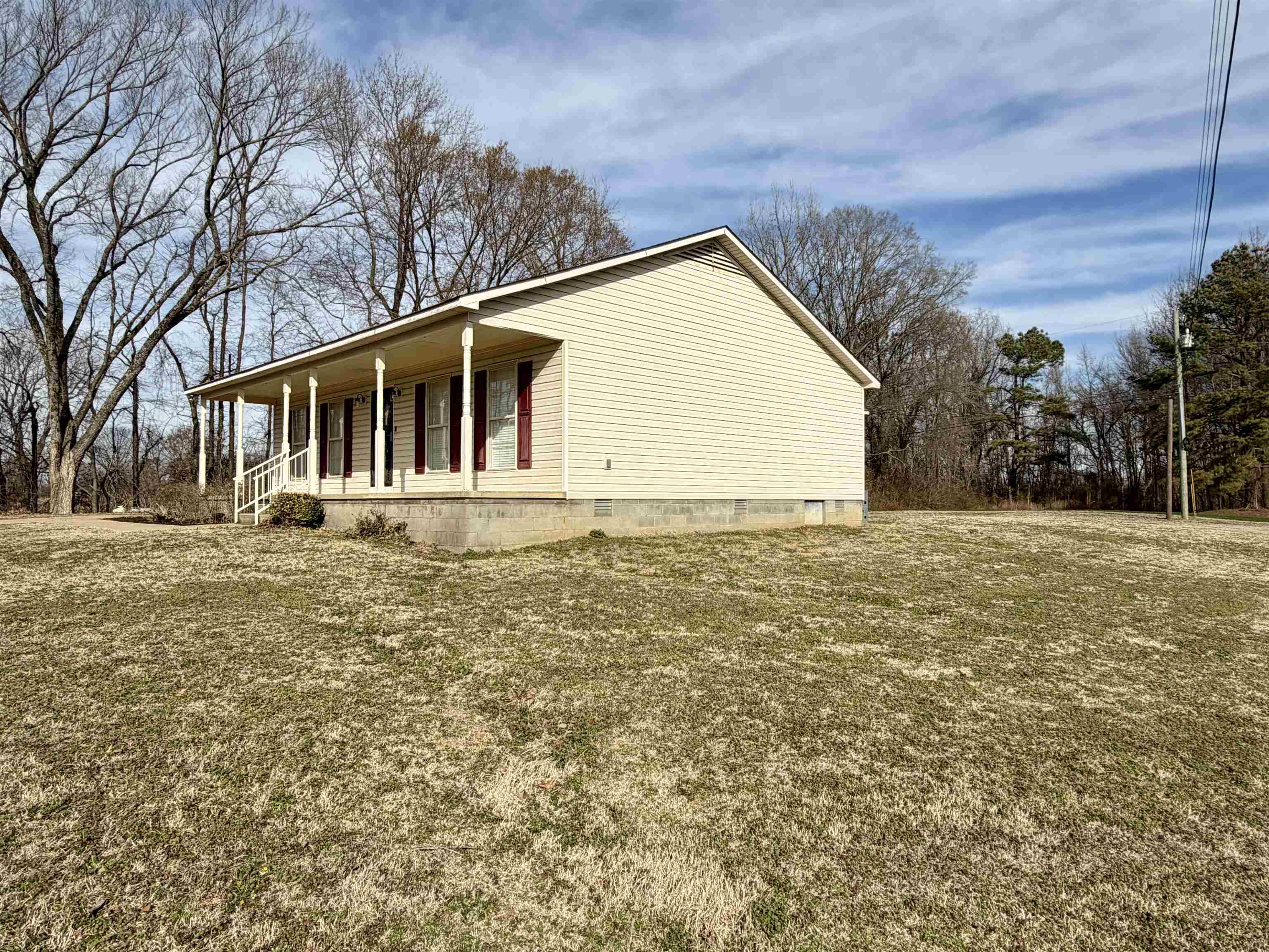 1086 Sloan Road Burlison, TN 38015 - Photo 5 of 24 View of side of home featuring covered porch, crawl space, and a lawn