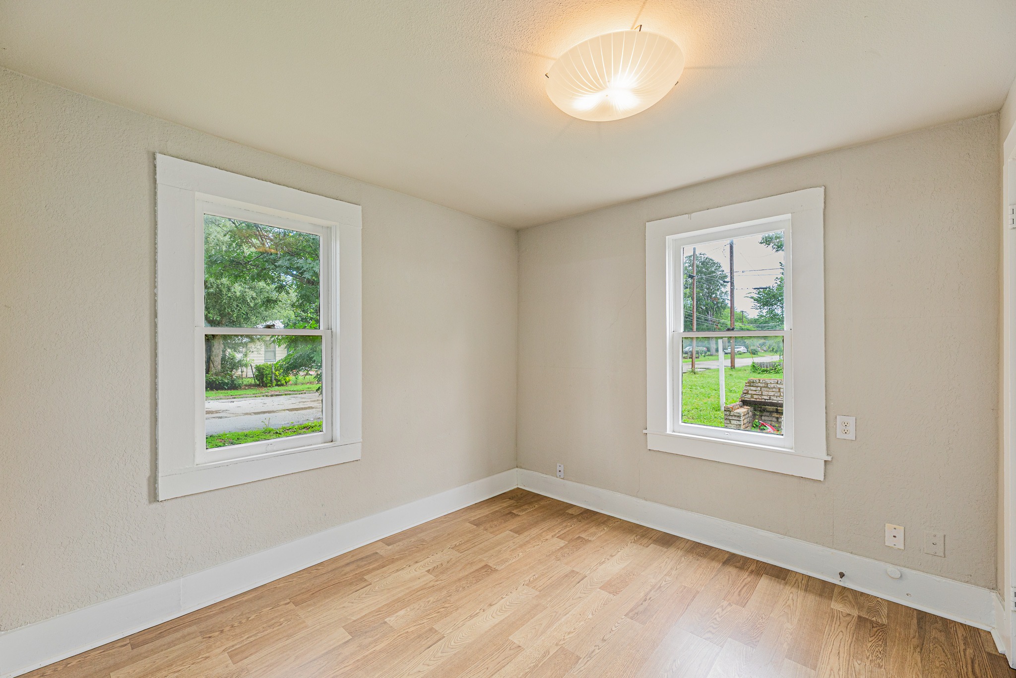 322 Blanco Avenue Luling, TX 78648 - Photo 15 of 20 Two large windows illuminate this peaceful room, showcasing fresh flooring and ample natural light.