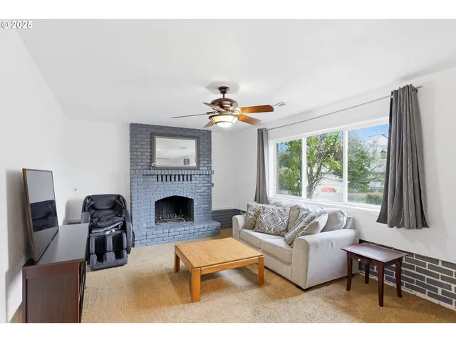 a living room with furniture a fireplace and a large window