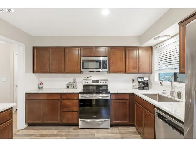 a kitchen with stainless steel appliances granite countertop a sink stove and microwave