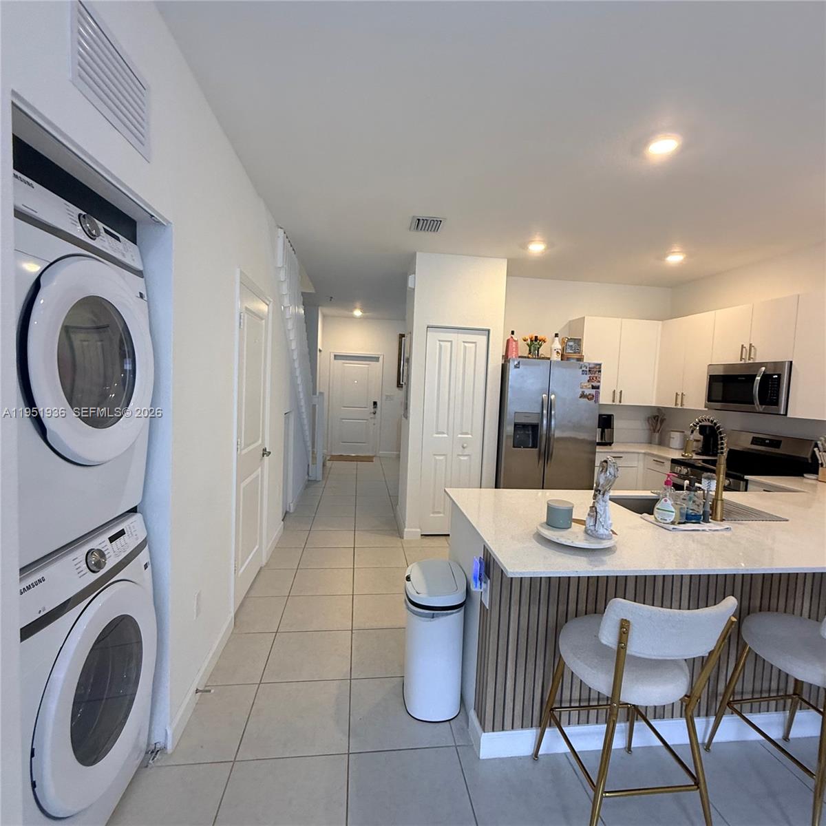 29224 Southwest 162nd Avenue Homestead, FL 33033 - Photo 13 of 26 a kitchen with stainless steel appliances kitchen island granite countertop a table chairs and a refrigerator