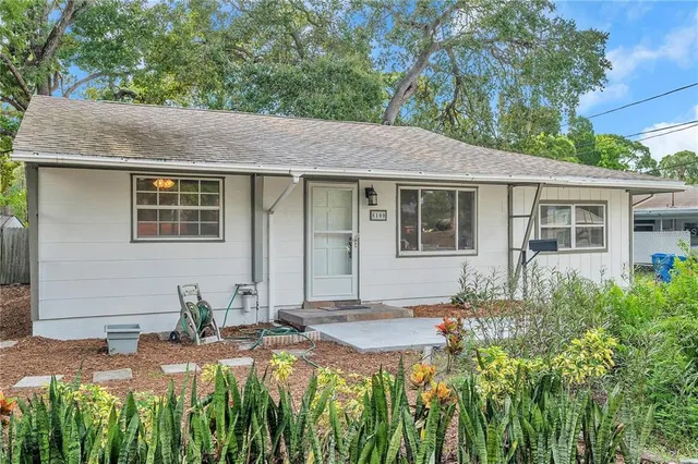 a backyard of a house with table and chairs