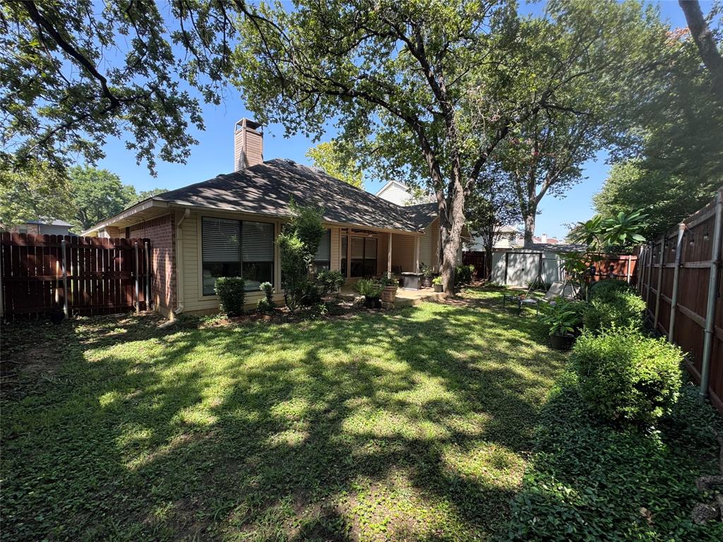 521 Post Oak Road Grapevine, TX 76051 - Photo 2 of 16 Expansive backyard featuring a manicured lawn, mature trees, and privacy fencing