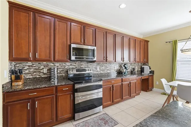 a kitchen with stainless steel appliances granite countertop wooden cabinets a stove top oven a sink and dishwasher