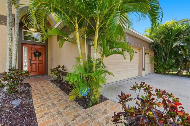 a couple of palm trees sitting in front of a house