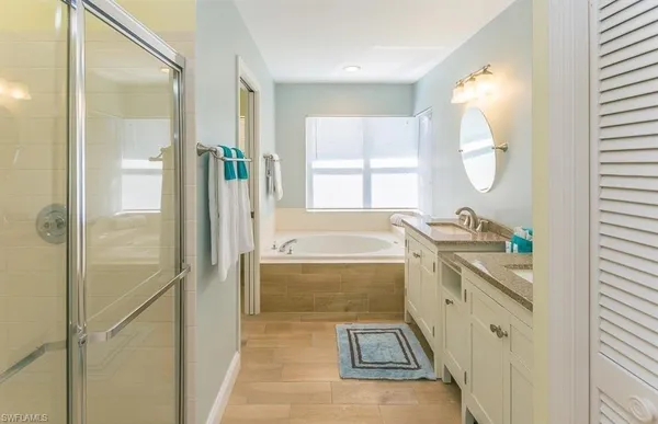 a bathroom with a tub sink and mirror
