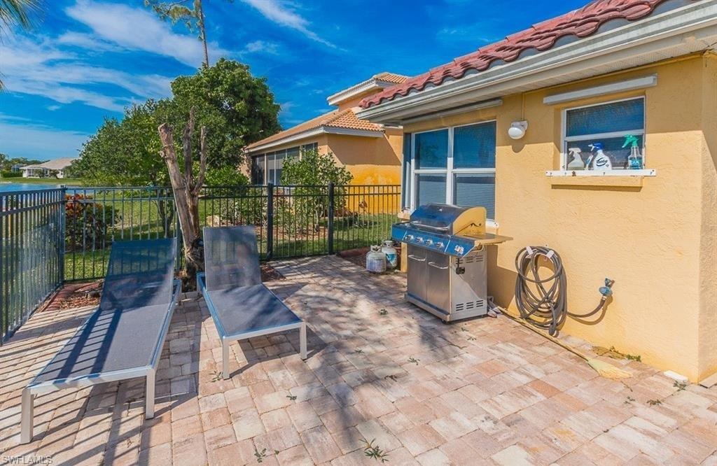 5077 Mabry Drive Naples, FL 34112 - Photo 21 of 24 a view of a patio with table and chairs potted plants with wooden floor and fence