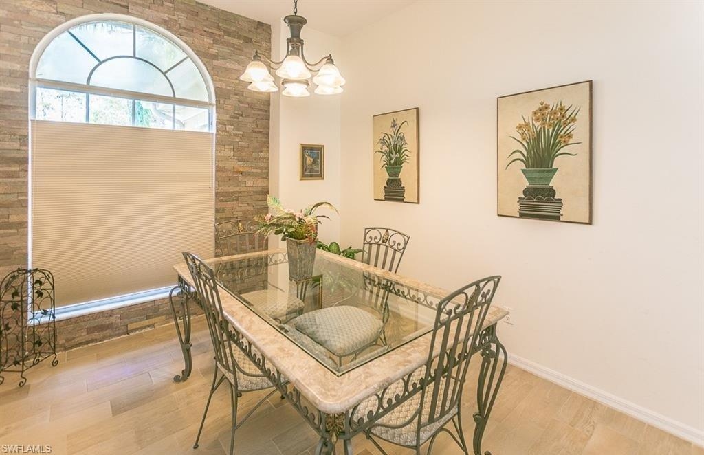 5077 Mabry Drive Naples, FL 34112 - Photo 10 of 24 a view of a dining room with furniture and chandelier