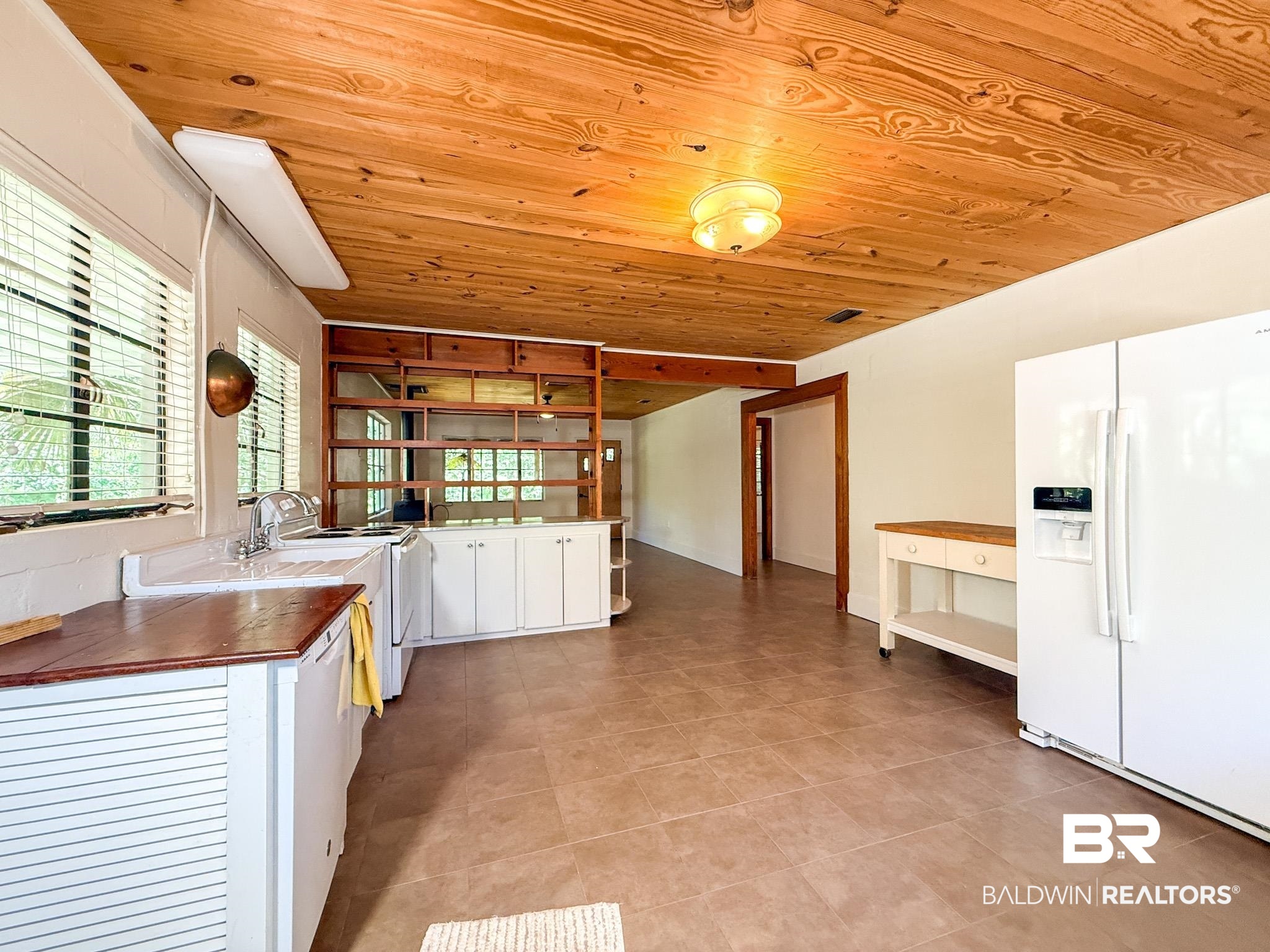 18711 Keller Road Foley, AL 36535 - Photo 11 of 38 Spacious kitchen featuring a wood-finish ceiling, tile flooring, white cabinetry, and wood-finish countertops