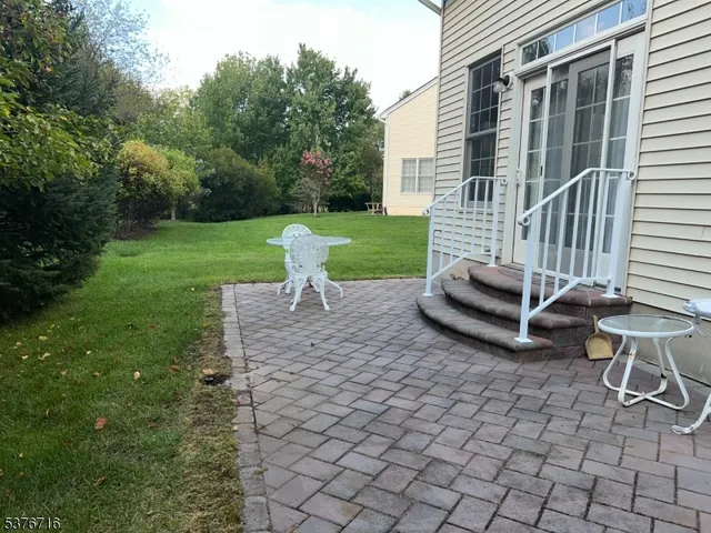 a view of a chair and table in backyard of the house