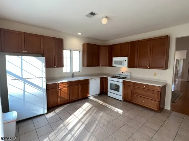 a large kitchen with stainless steel appliances granite countertop a stove a sink and a refrigerator
