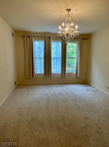 a view of a big room with windows and chandelier