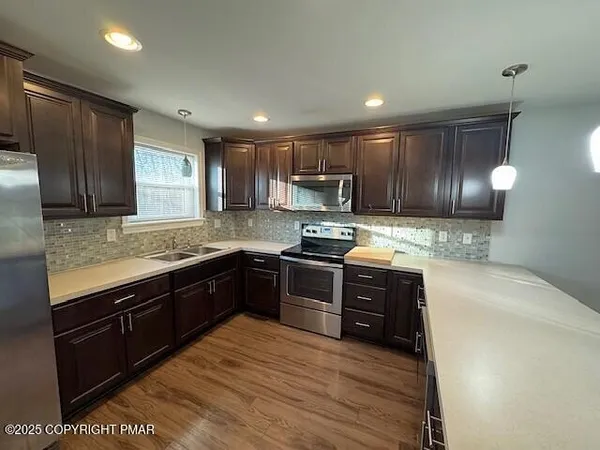 a kitchen with stainless steel appliances granite countertop wooden cabinets a stove top oven a sink and dishwasher