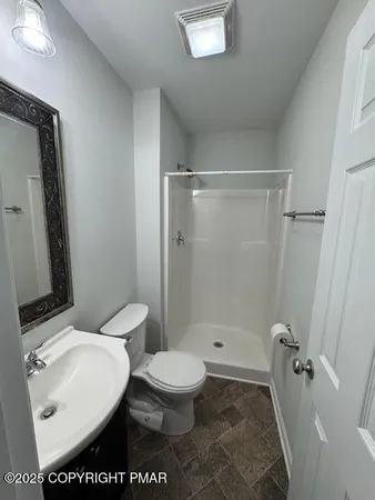 a bathroom with a toilet a sink and shower