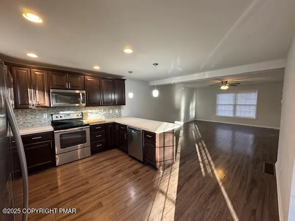 a large kitchen with stainless steel appliances granite countertop a stove a sink dishwasher a microwave oven with granite countertops and cabinets