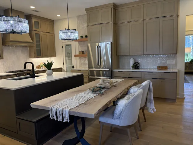 a kitchen with stainless steel appliances granite countertop a sink a stove a refrigerator and island