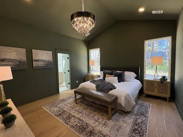 a bedroom with a bed and a chandelier