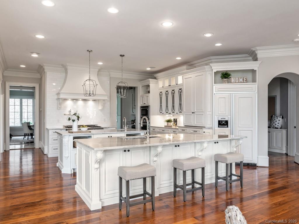 404 Eagle Bend Drive Waxhaw, NC 28173 - Photo 18 of 46 a kitchen with stainless steel appliances kitchen island granite countertop a stove a refrigerator a kitchen island with white cabinets and wooden floor