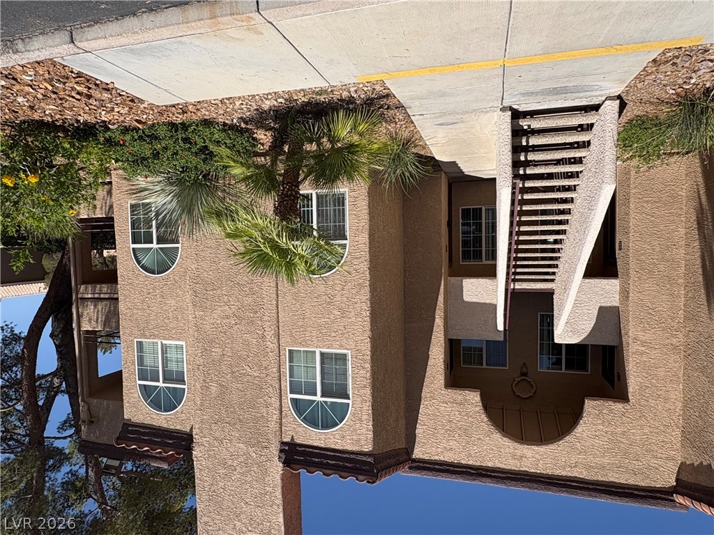 9325 West Desert Inn Road, Unit 123 Las Vegas, NV 89117 - Photo 2 of 36 A classic stucco building with arched windows and mature palms welcomes residents home.