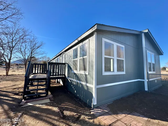 a view of backyard with deck and wooden fence