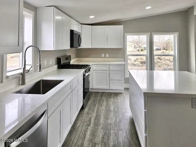a kitchen with a sink a stove and cabinets