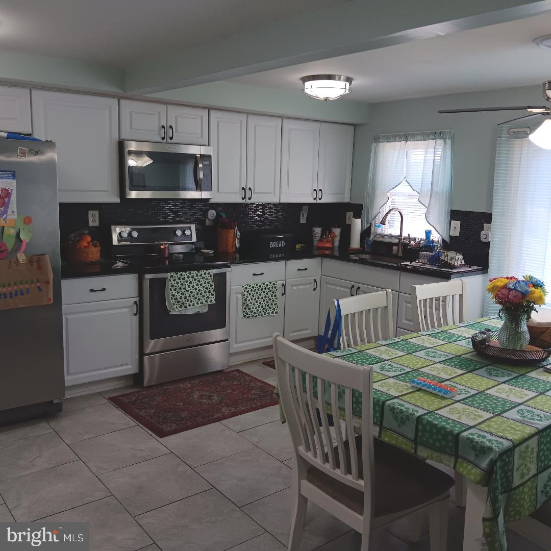 33 Left Wing Drive Baltimore, MD 21220 - Photo 13 of 17 a kitchen with stainless steel appliances granite countertop a stove top oven a sink dishwasher and cabinets