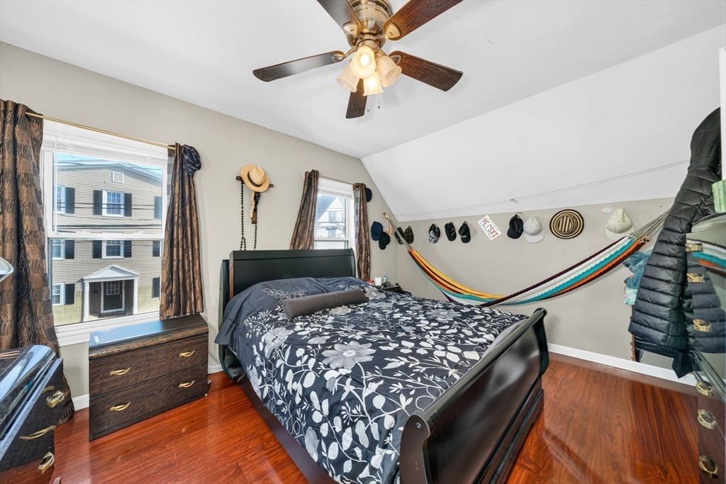 107 Apsley Street Hudson, MA 01749 - Photo 20 of 26 a bed room with a bed window and a chandelier
