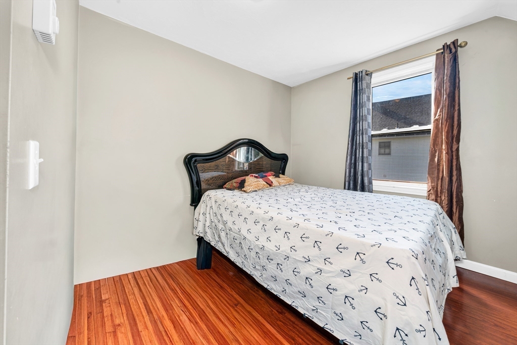 107 Apsley Street Hudson, MA 01749 - Photo 21 of 26 a bedroom with a bed and wooden floor