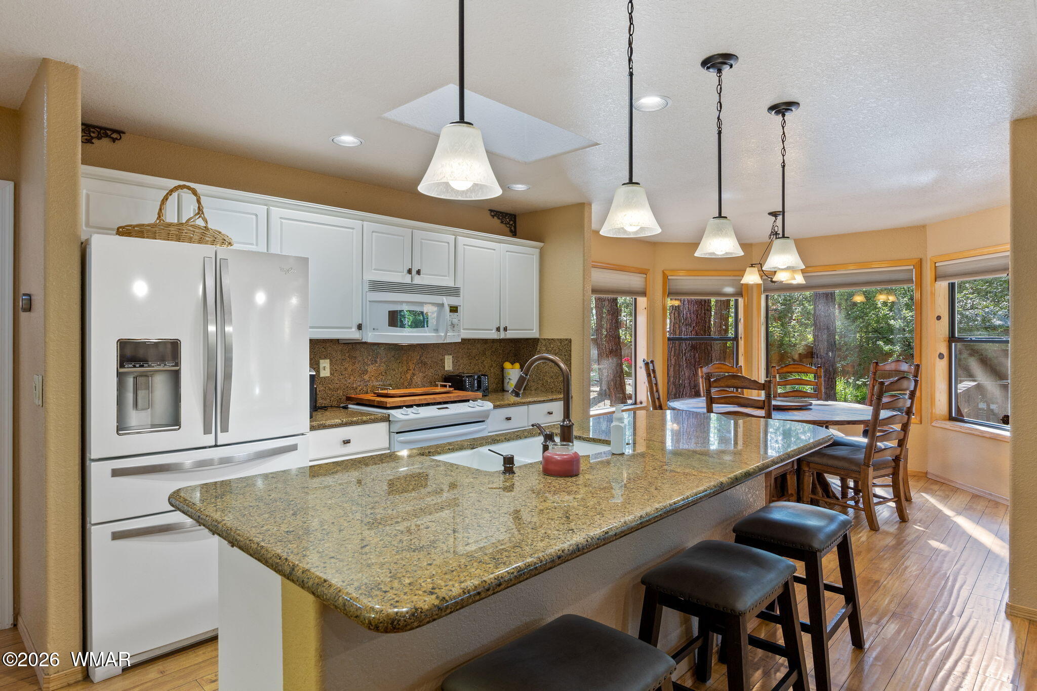 6735 Sunset Trail Pinetop, AZ 85935 - Photo 10 of 33 a kitchen with stainless steel appliances granite countertop a stove a sink a oven a dining table and chairs with wooden floor