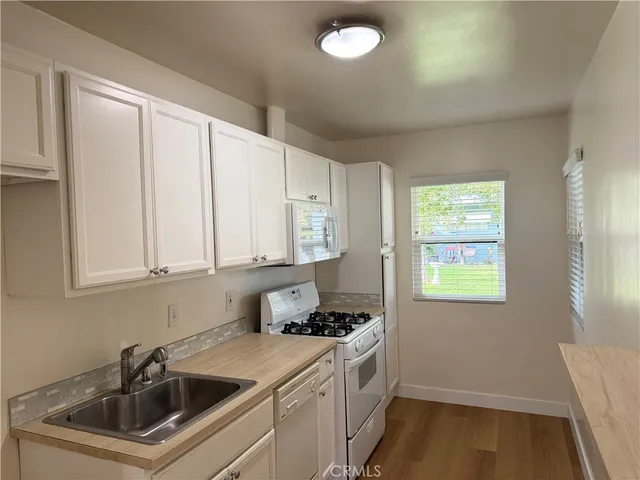 a kitchen with a sink cabinets and a window