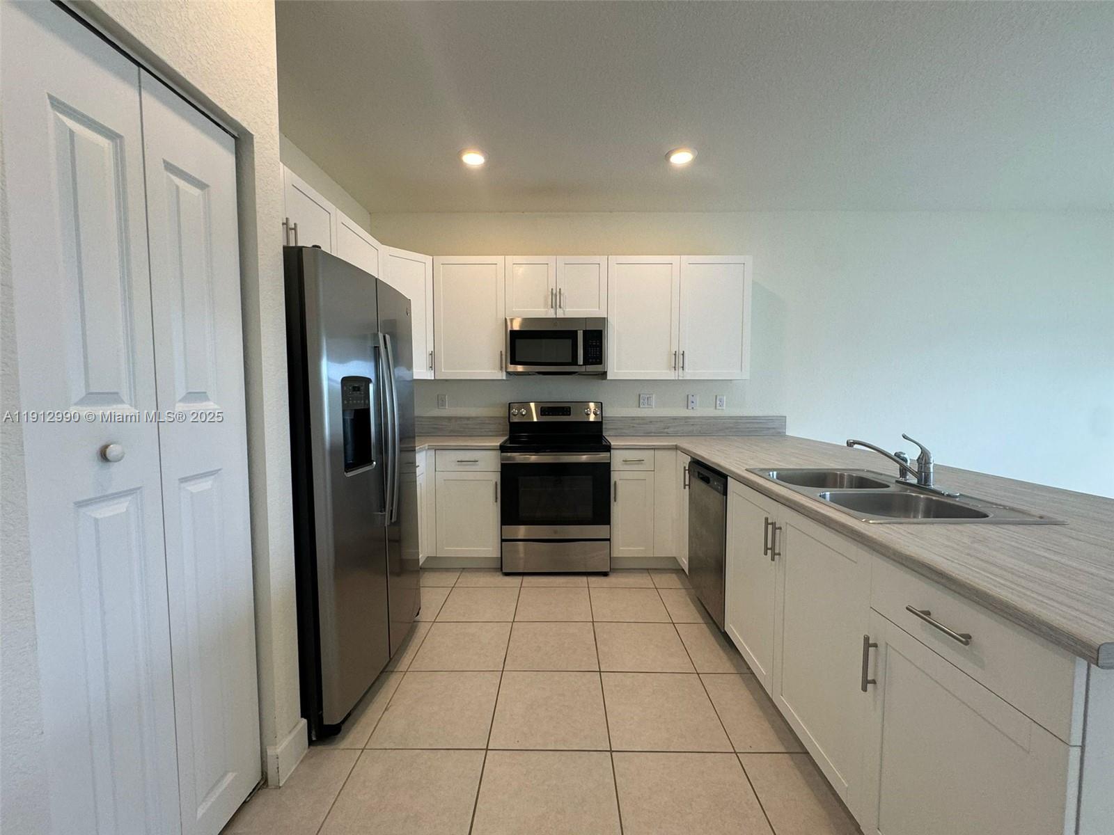 11325 West 34th Way Hialeah, FL 33018 - Photo 11 of 46 a kitchen with granite countertop a refrigerator and a sink
