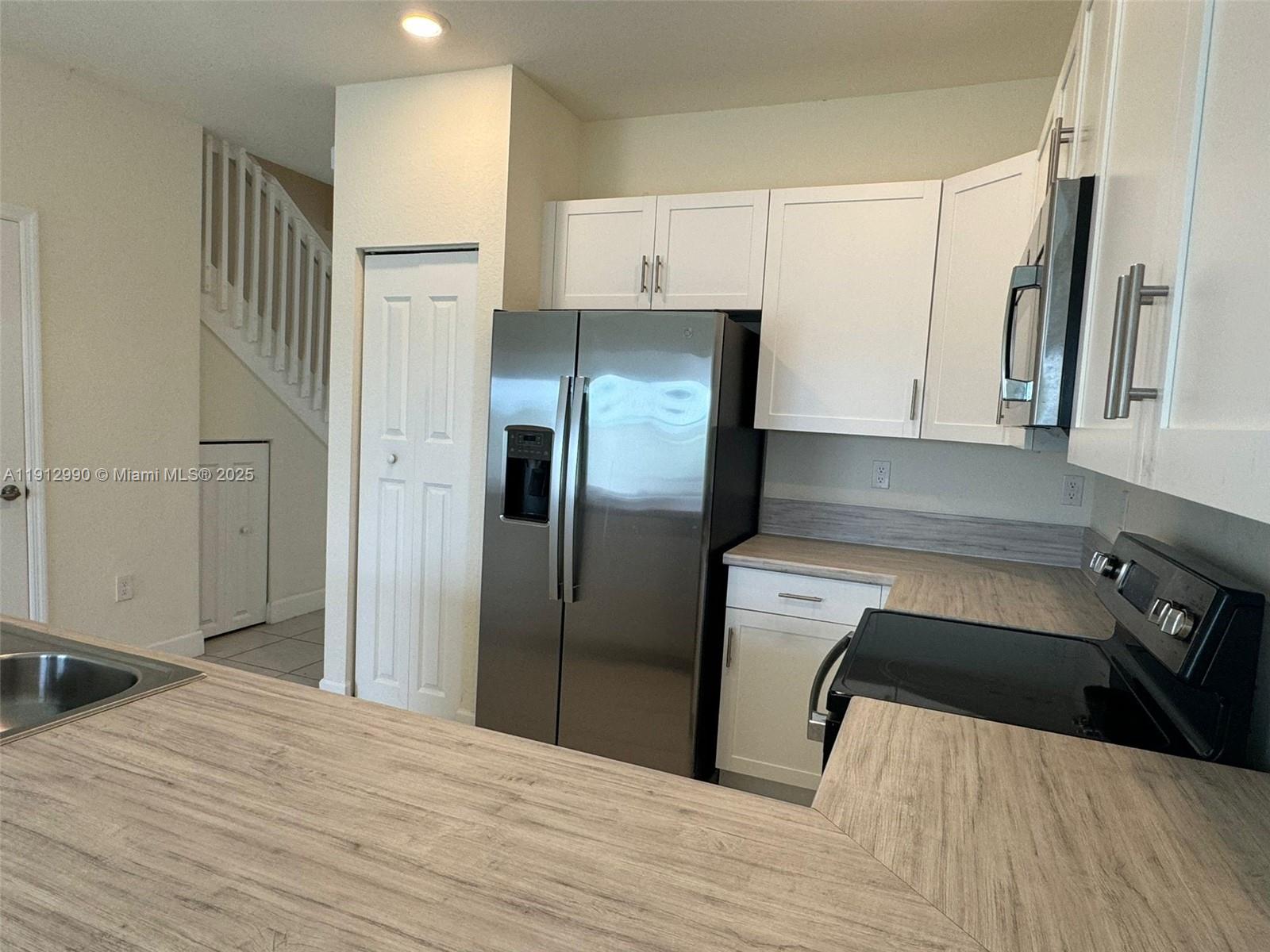 11325 West 34th Way Hialeah, FL 33018 - Photo 12 of 46 a kitchen with a refrigerator and a sink