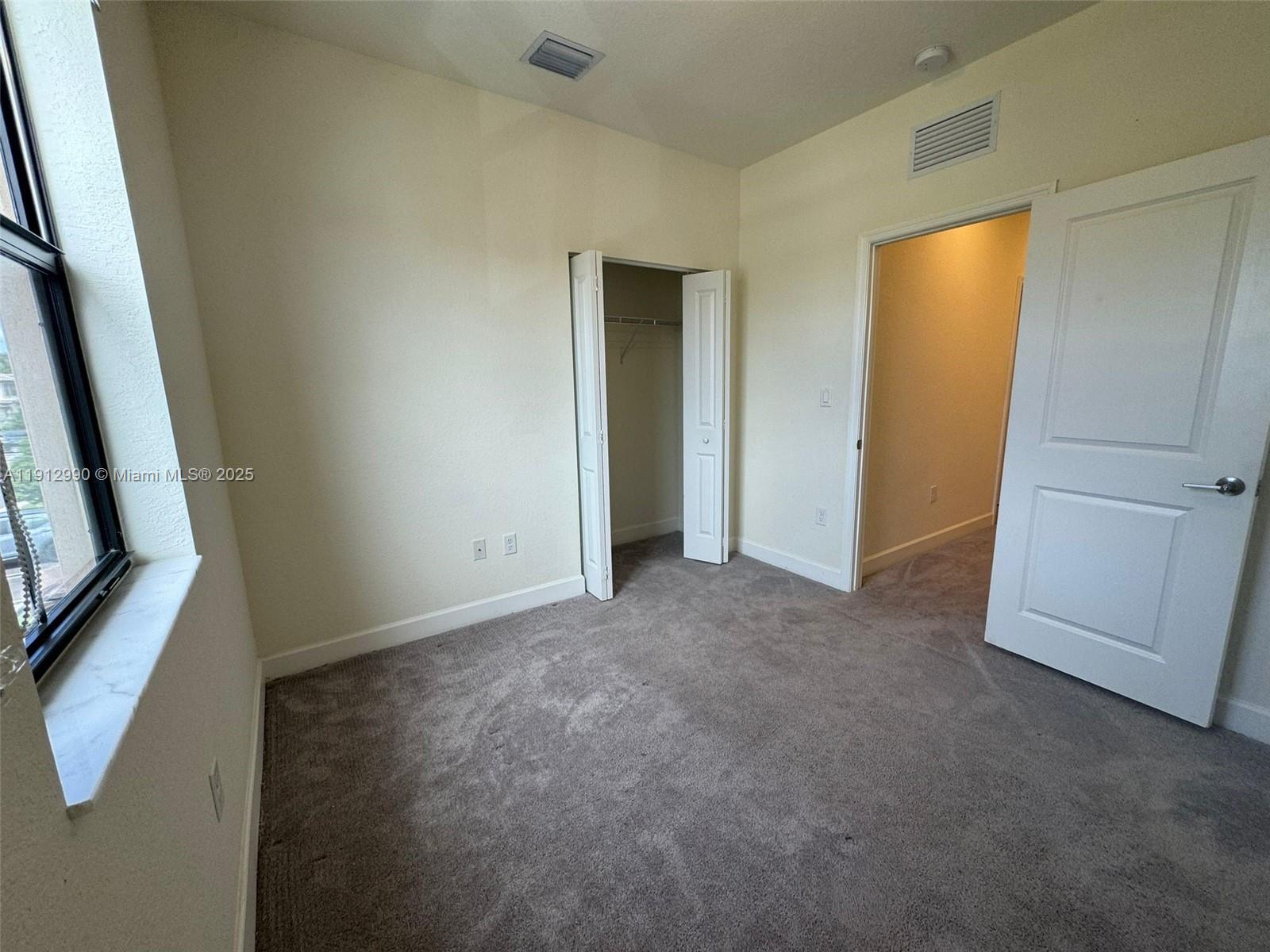 11325 West 34th Way Hialeah, FL 33018 - Photo 16 of 46 a view of an empty room with wooden floor and a window