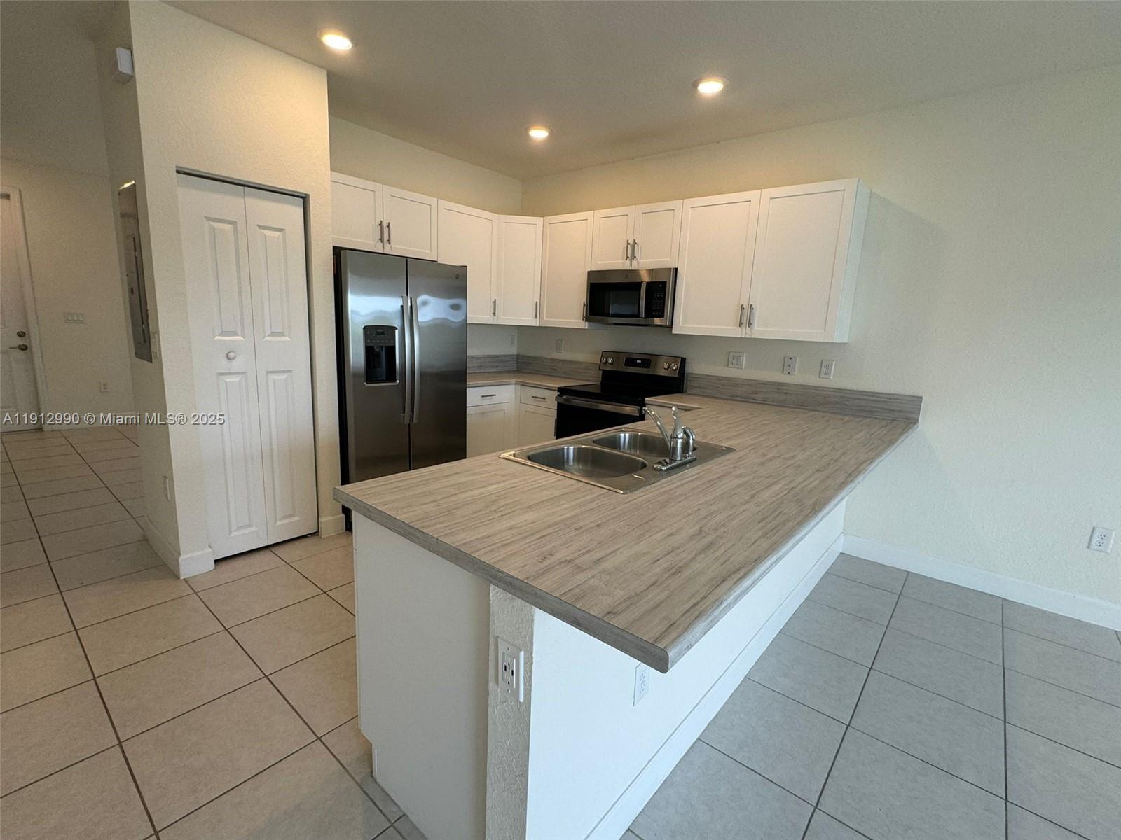 11325 West 34th Way Hialeah, FL 33018 - Photo 8 of 46 a kitchen with stainless steel appliances a sink and microwave