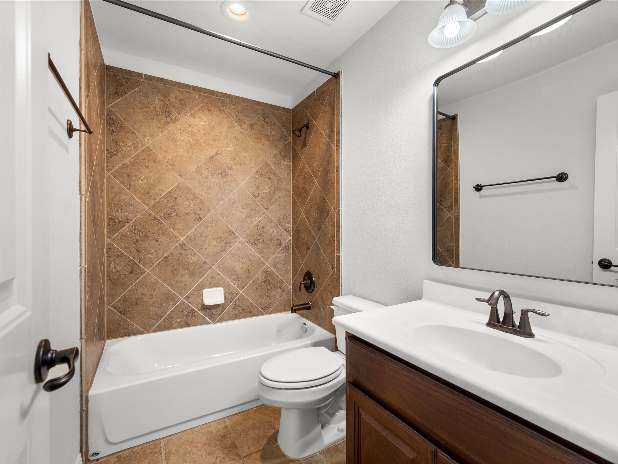 323 Arbor Ridge Lane Conroe, TX 77384 - Photo 29 of 40 Clean, classic, and ready to go. Tub-shower combo, great vanity space, and that tile work holds up. Kids' bath, guest bath, you're covered either way.