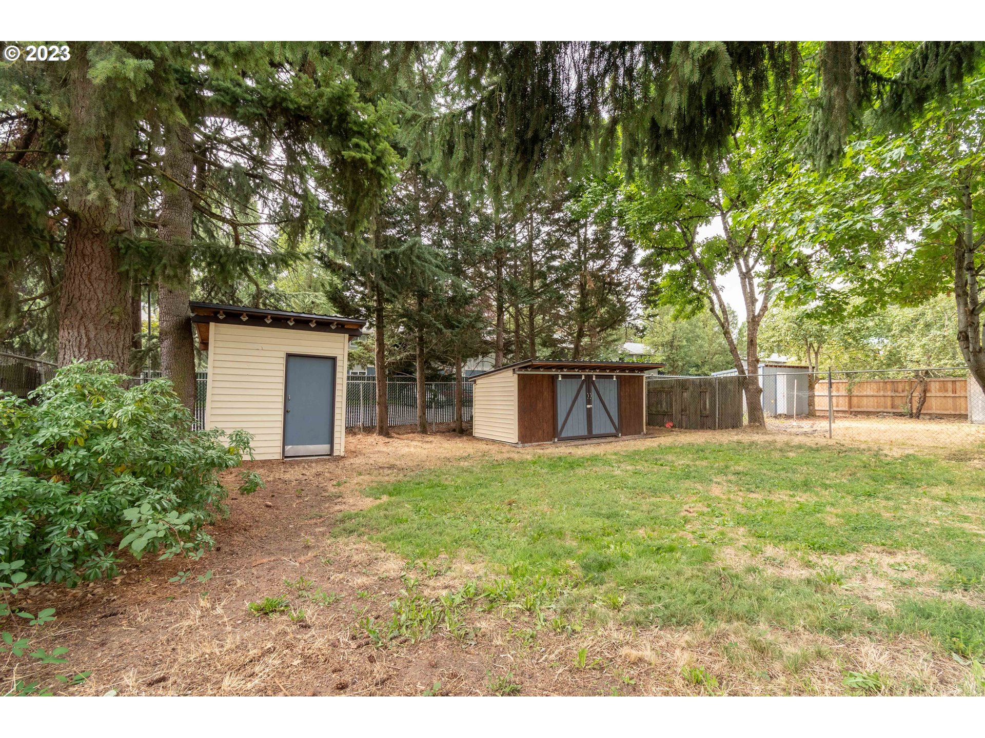 535 West M Street Springfield, OR 97477 - Photo 31 of 48 a backyard of a house with large trees and plants
