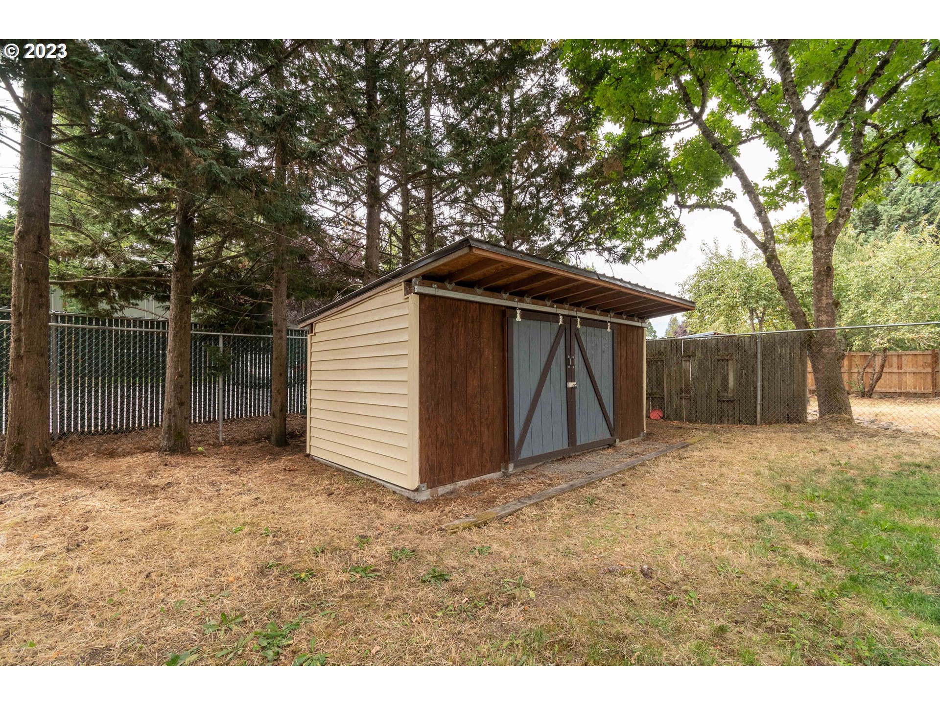 535 West M Street Springfield, OR 97477 - Photo 33 of 48 a view of backyard with small cabin and wooden fence
