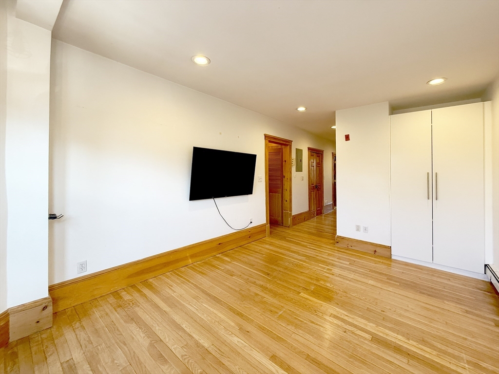 148 Berkshire Street, Unit 4 Cambridge, MA 02141 - Photo 5 of 17 a view of an empty room with wooden floor