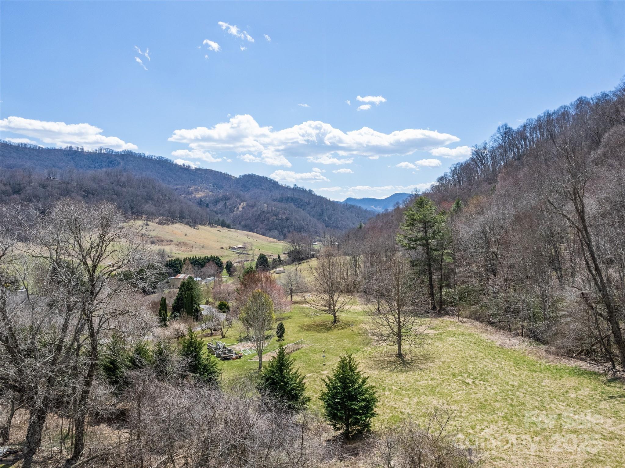 153 Trinity Drive Clyde, NC 28721 - Photo 11 of 38 a view of a big yard with mountains in the background