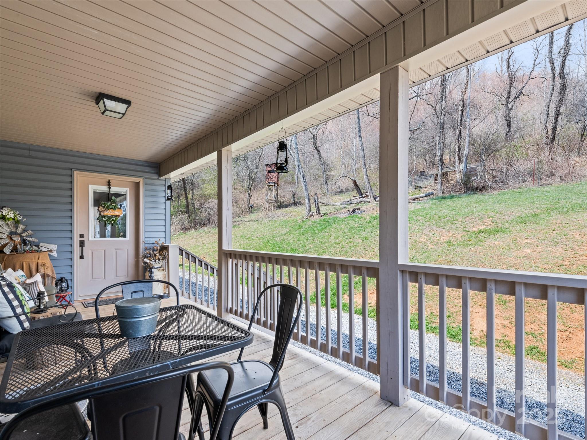 153 Trinity Drive Clyde, NC 28721 - Photo 15 of 38 a view of a patio with a table chairs and a backyard