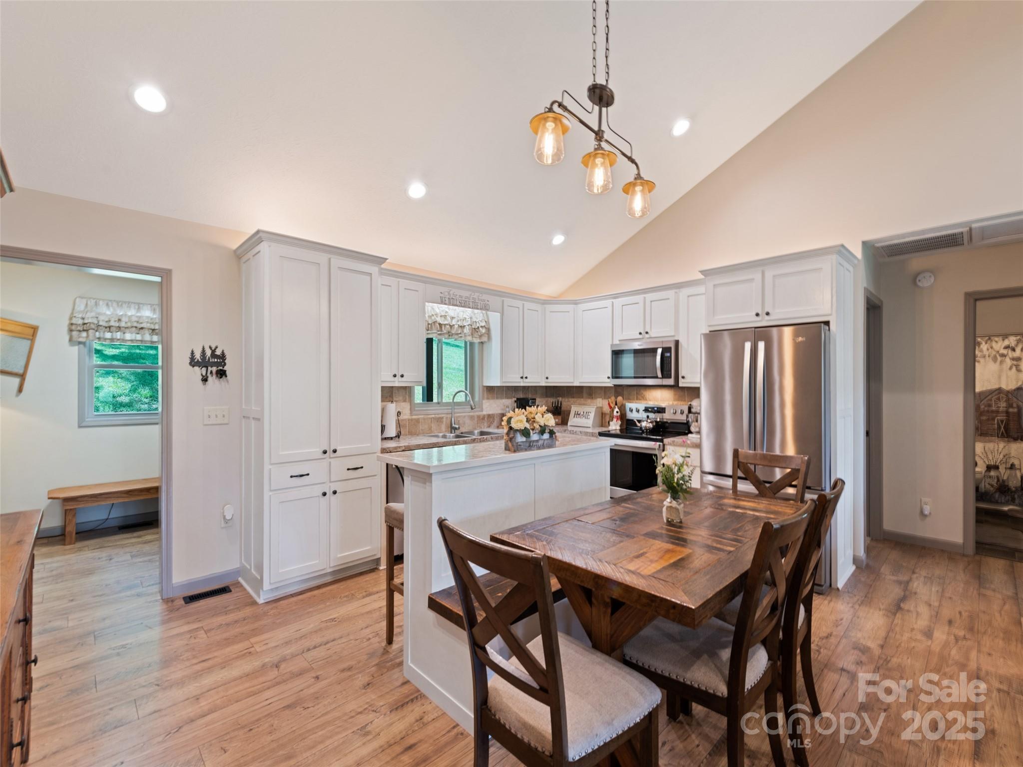 153 Trinity Drive Clyde, NC 28721 - Photo 18 of 38 a kitchen with stainless steel appliances granite countertop a dining table chairs refrigerator and microwave