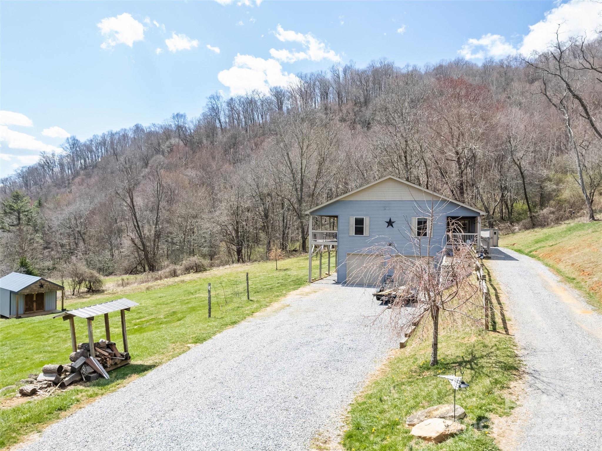 153 Trinity Drive Clyde, NC 28721 - Photo 5 of 38 a front view of a house with a yard and garage