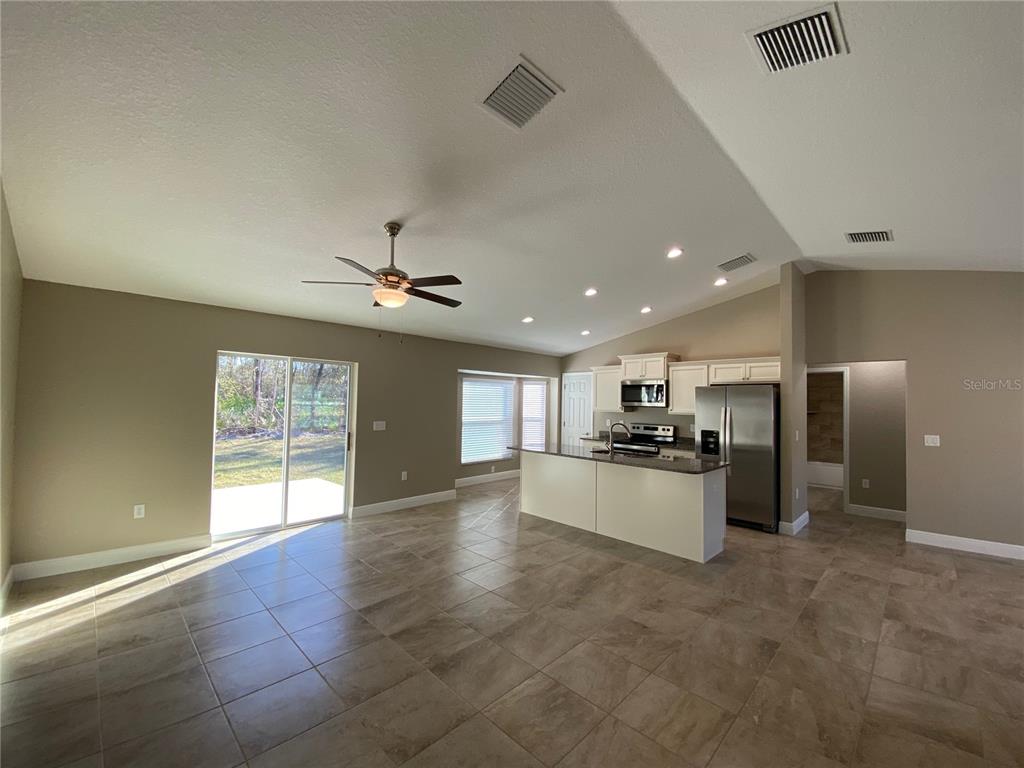 4110 Southwest 132nd Lane Ocala, FL 34473 - Photo 6 of 30 a large kitchen with a stove a refrigerator and a kitchen island