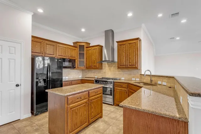 a large kitchen with stainless steel appliances granite countertop a stove a sink and a refrigerator