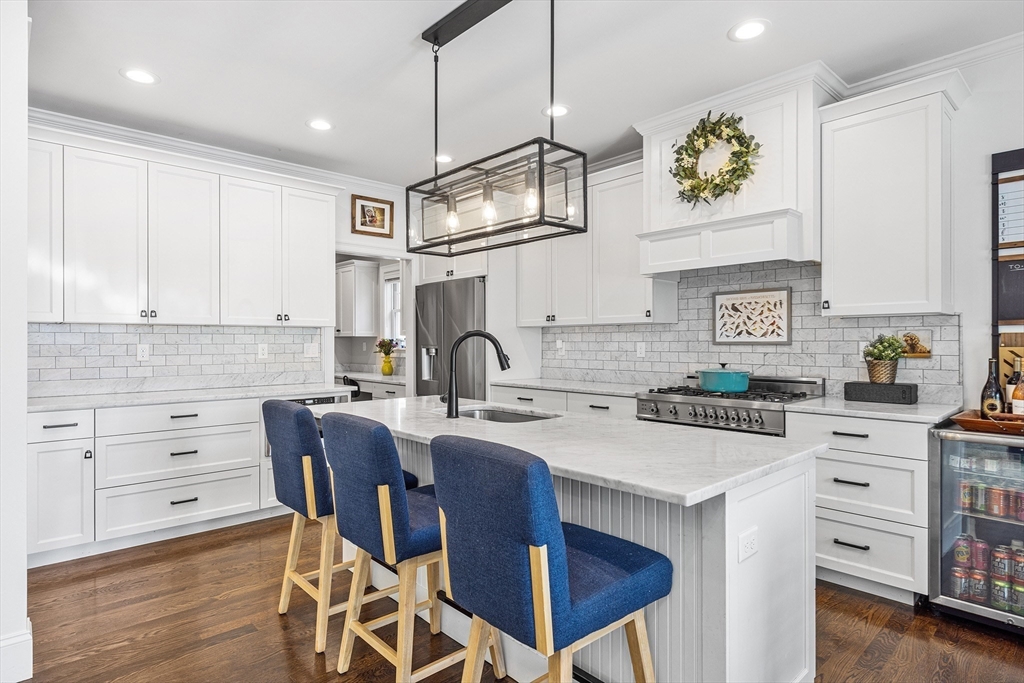 48 Hillcrest Road Waltham, MA 02451 - Photo 11 of 42 a kitchen with stainless steel appliances granite countertop a stove top oven a sink a dining table and chairs with wooden floor